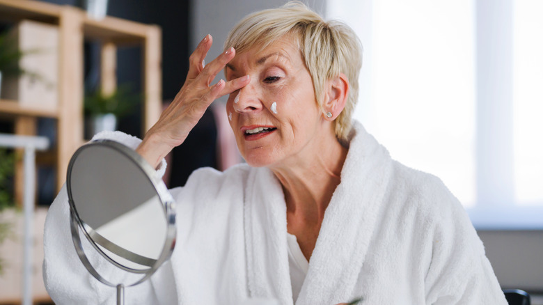 older woman applying face cream