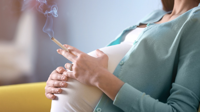 Pregnant woman holding a cigarette