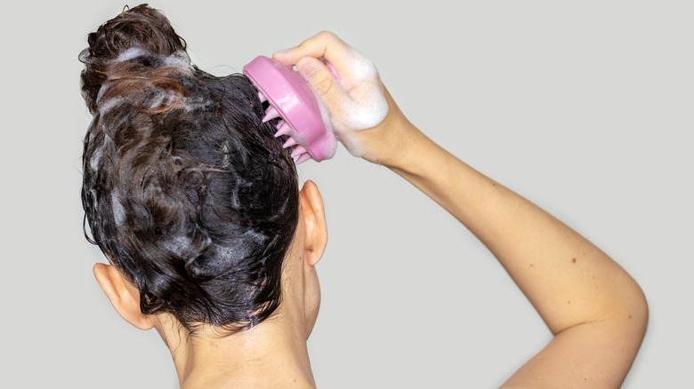 Woman using scalp massager