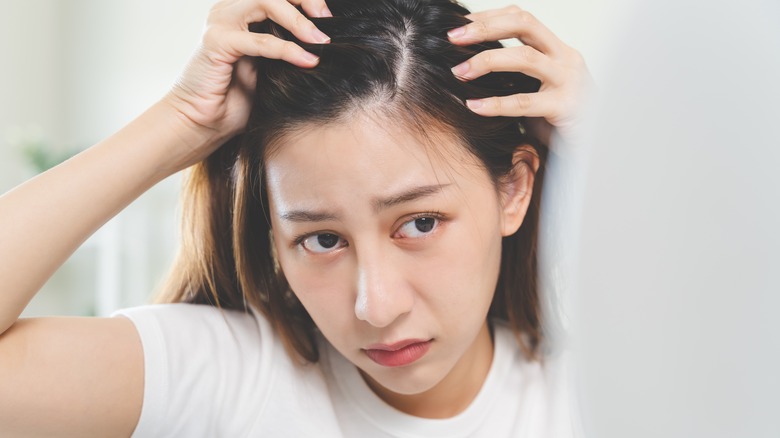 Woman looking at thinning hair