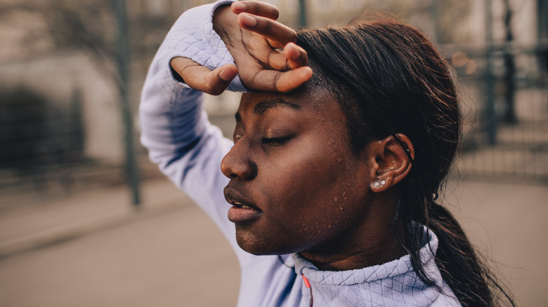 Woman wiping sweat off her face