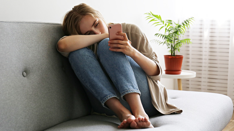 Woman looks at her phone, concerned