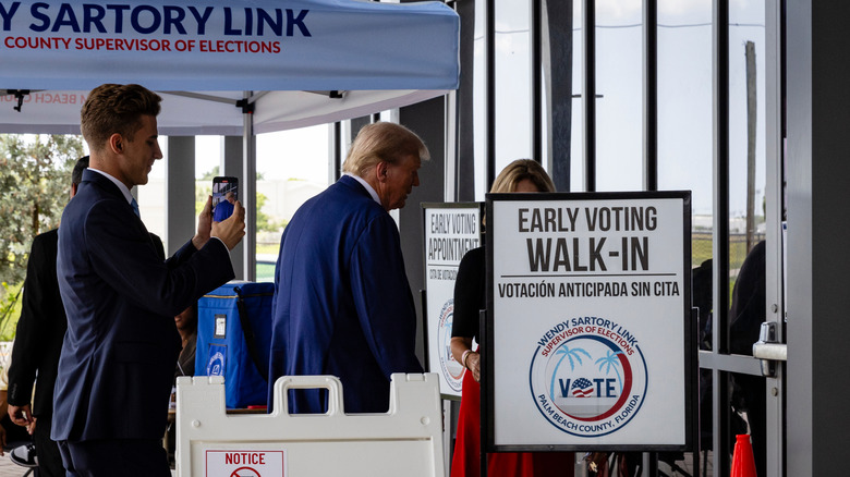 Donald Trump walking past "Early Voting" sign