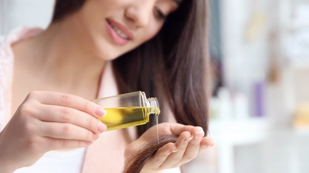 Woman applying oil on her split ends