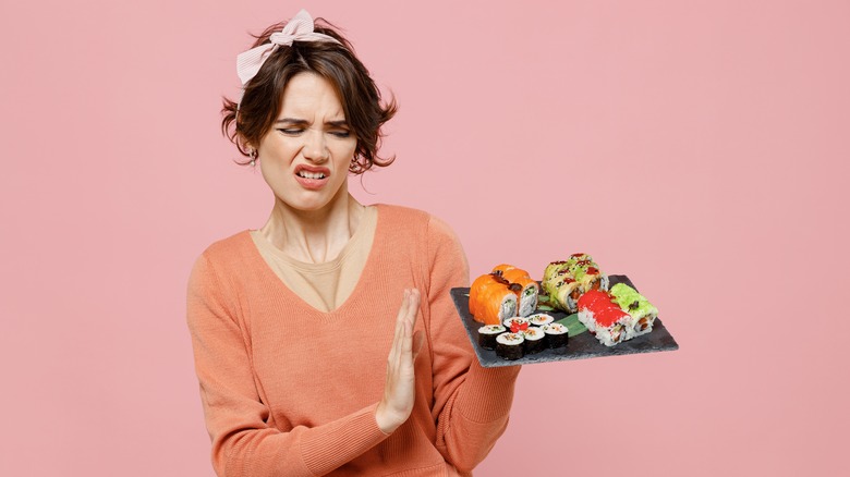 woman looking disgusted at sushi