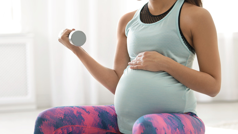 Pregnant woman holding a dumbbell