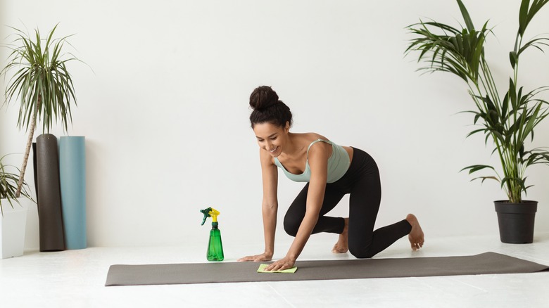 Woman cleaning yoga mat 