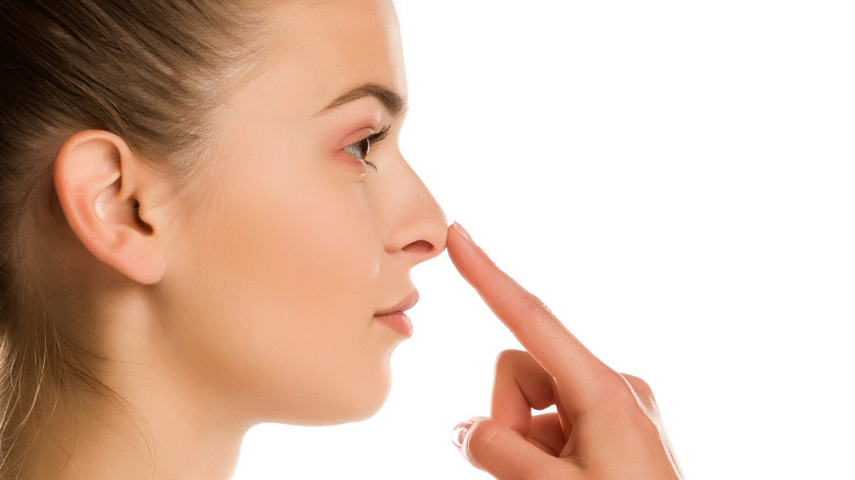 woman pressing nose tip