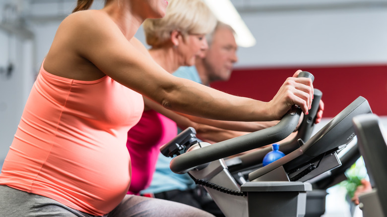 Pregnant woman riding a stationary bike