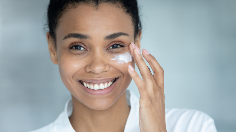 Black woman applying face cream