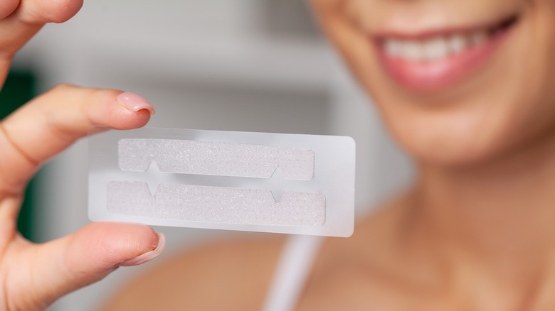 Woman holding teeth whitening strips 