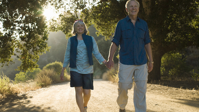 Elderly couple holding hands and walking