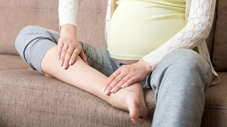 pregnant woman massaging legs