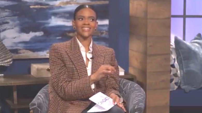 Candace Owens smiling in an oversized blazer 