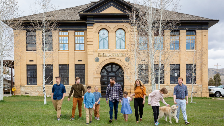 Candis and Andy Meredith and family in front of schoolhouse