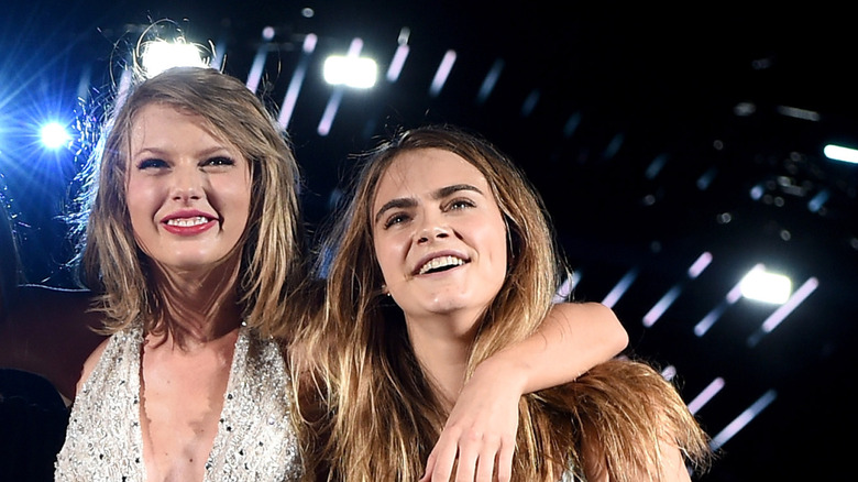 Taylor Swift with her arm around Cara Delevingne