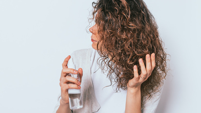 Woman spraying hair