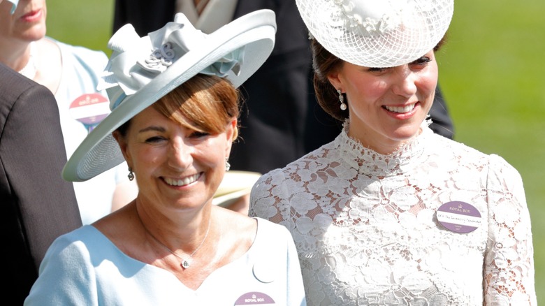 Carole Middleton Kate Middleton smiling, wearing fascinators