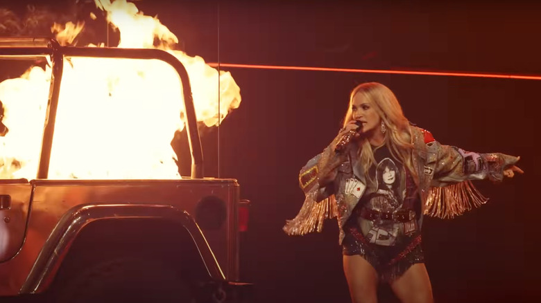 Carrie Underwood next to burning car