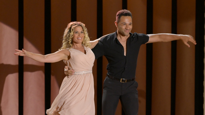 Cat Cora dancing in a pink dress with Corbin Bleu