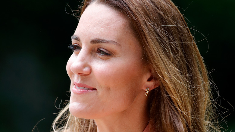 Kate Middleton smiling wearing gold hoop earrings