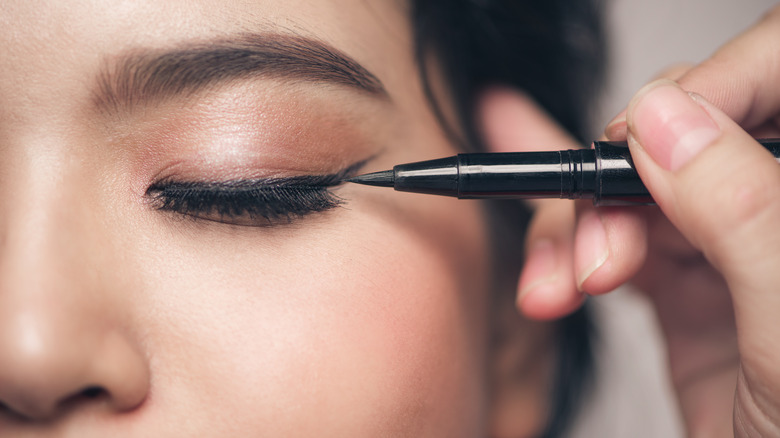 woman having eyeliner applied