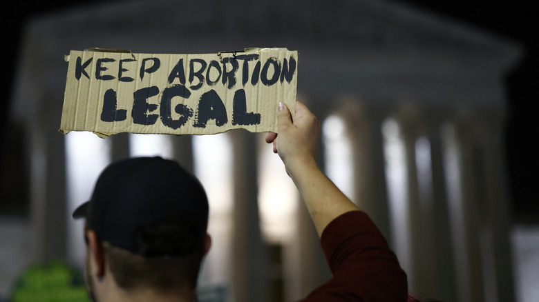 Man holds sign reading "Keep Abortion Legal" outside Supreme Court