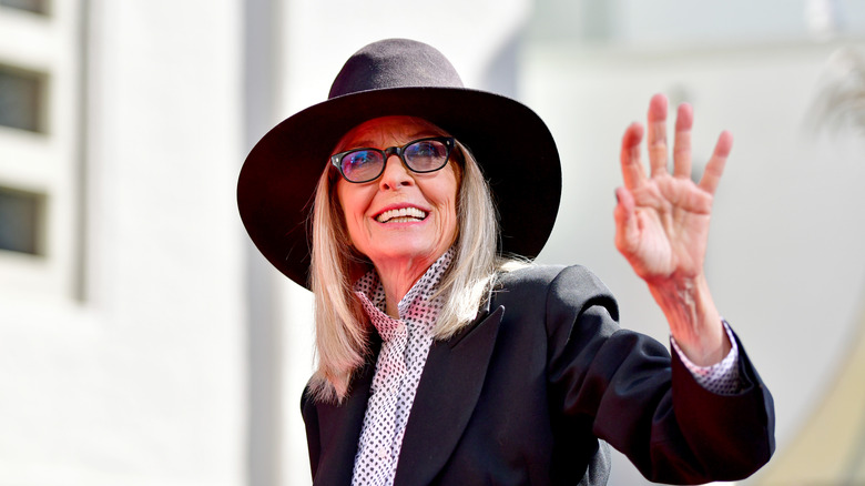 Diane Keaton waving in a hat