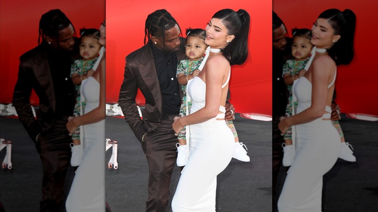 Travis Scott and Kylie Jenner posing with Stormi Webster at a premiere in 2019