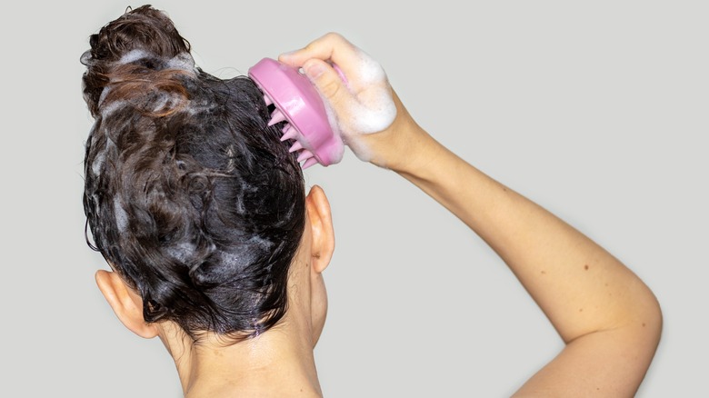 A woman massaging her scalp