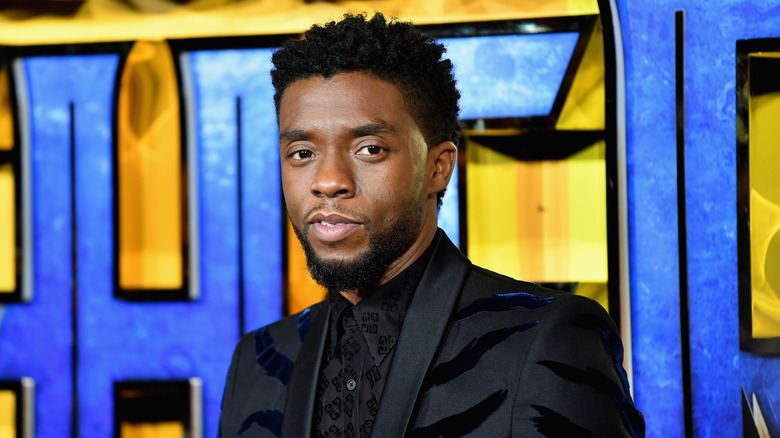 Chadwick Boseman wearing a dark suit at a movie premiere