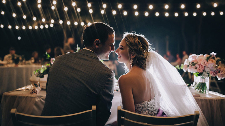 Newlyweds smile at each other during wedding reception