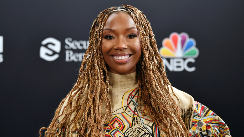 Brandy Norwood smiling in braids at a red carpet event