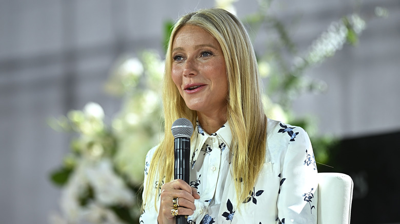 Gwyneth Paltrow speaking into a microphone at an event