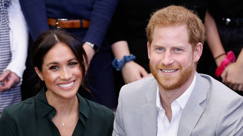 Prince Harry and Meghan Markle smile for a photo. 