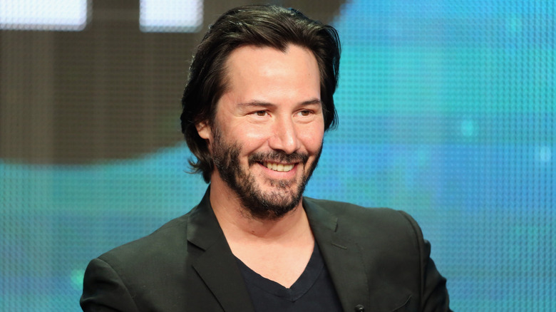 Keanu Reeves smiles for a photo