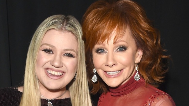 Kelly Clarkson and Reba McEntire smiling 