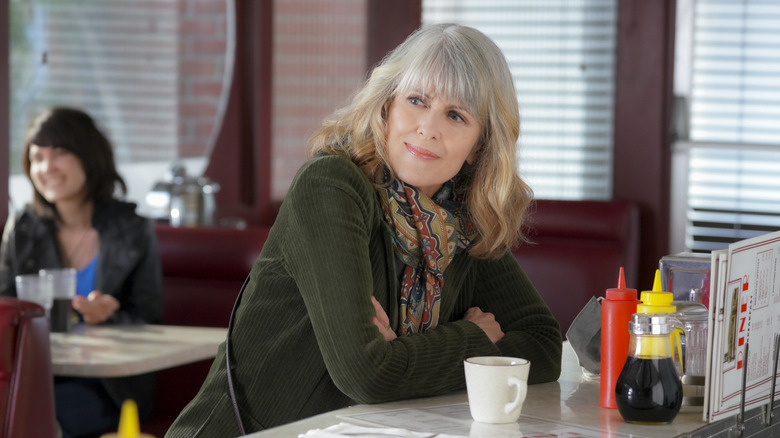 Pam Dawber leaning on counter, looking on