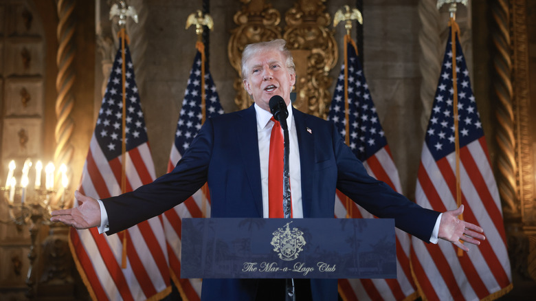 Donald Trump arms spread out Mar-a-Lago podium