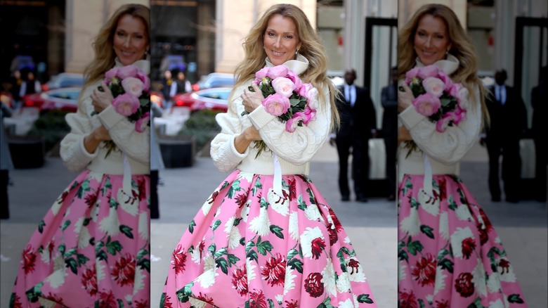 Celine Dion holding flowers and smiling