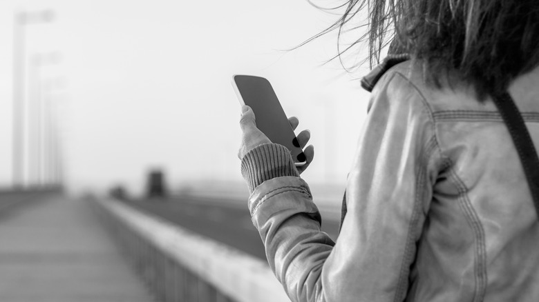 black and white pic of woman holding phone