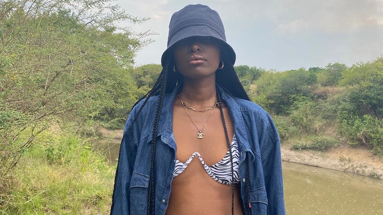 woman in bucket hat by river