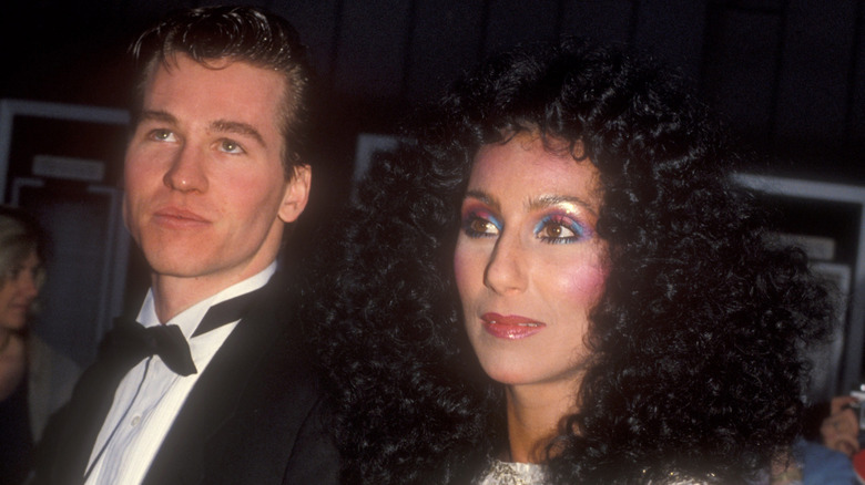 Cher and Val Kilmer arm in arm at an event in the 1980s