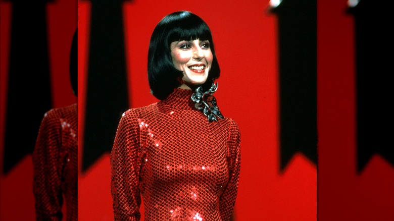 Cher wearing a red dress and bob haircut