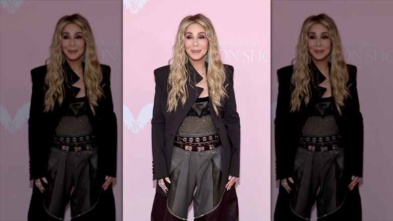 Cher walking the pink carpet in a wavy blond wig