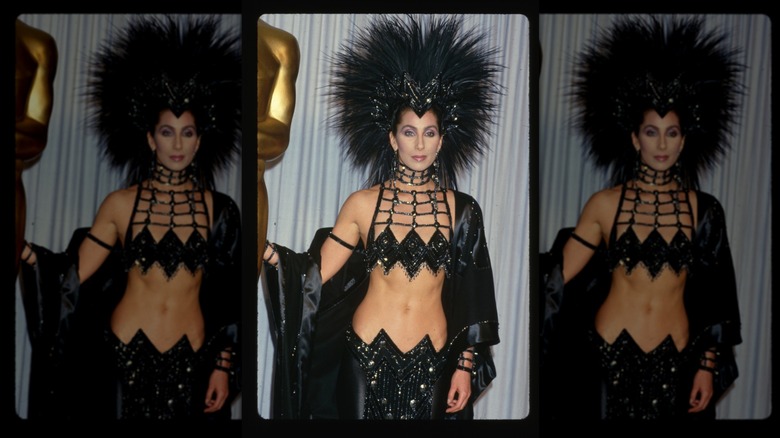 Cher wearing feather headpiece and black ensemble