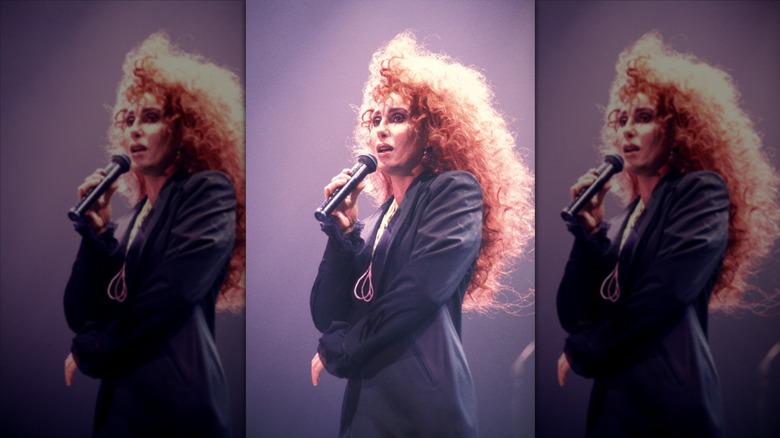 Cher performing in voluminous red wig