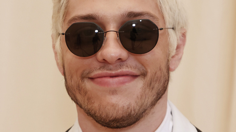 Pete Davidson smiles wearing sunglasses