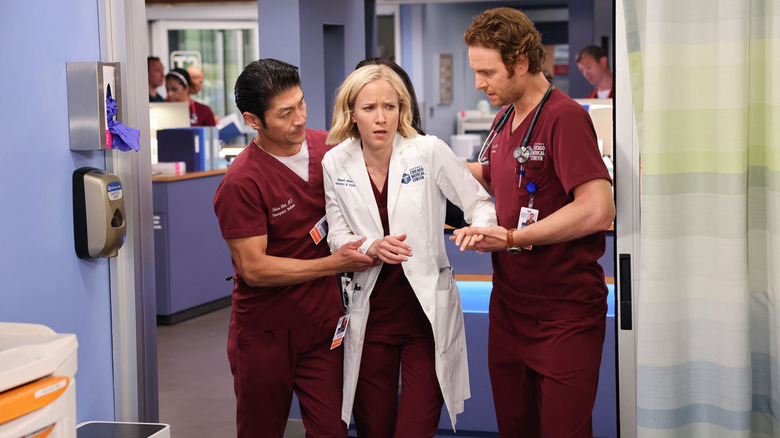 Jessy Schram being helped by two colleagues in Chicago Med