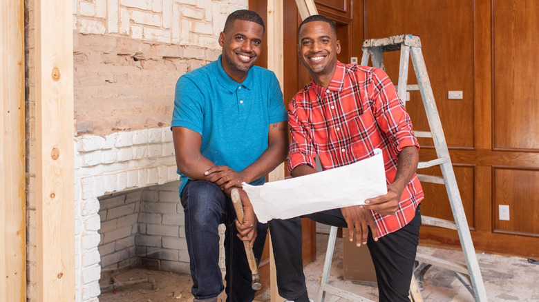 Calvin and Chris Lamont posing by fireplace